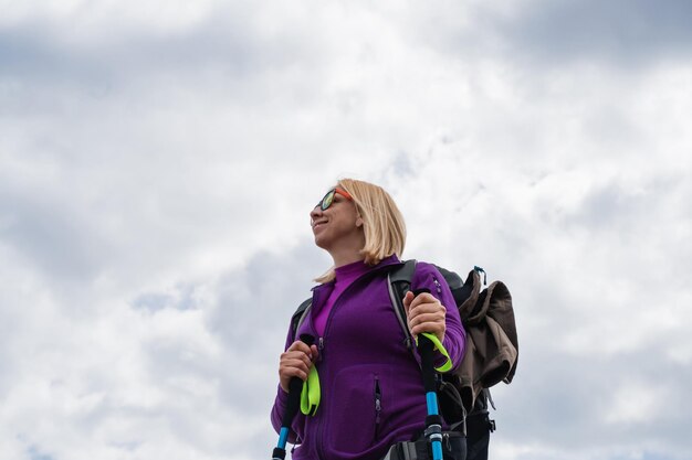 Foto donna con uno zaino che si gode la vista della montagna