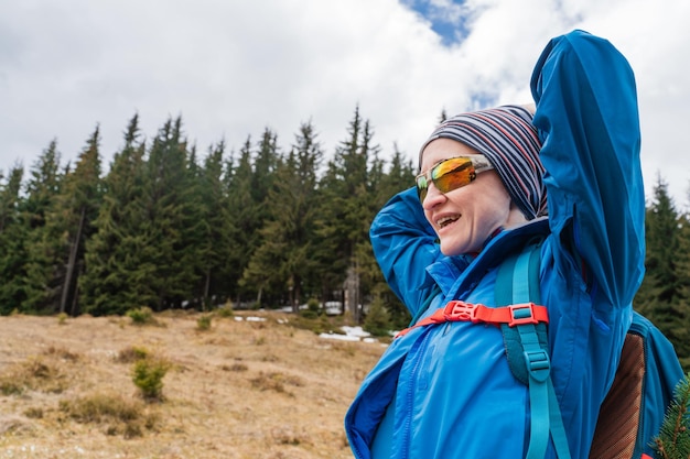 写真 バックパックを持った女性が山の景色を楽しんでいます