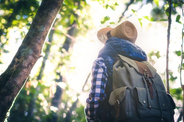 Женщина с рюкзаком и шляпой, любуясь прекрасным видом. Приключения в дикой природе.