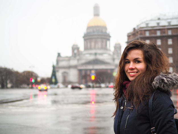 バックパックを持った女性が聖イサアク大聖堂とサンクトペテルブルクのメイン広場の近くを歩く