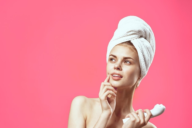 Woman with bare shoulders and cosmetology clean skin relaxation pink background