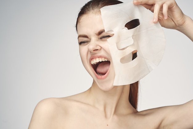 裸の肩とフェイスマスクのスキンケア化粧品を持つ女性。高品質の写真