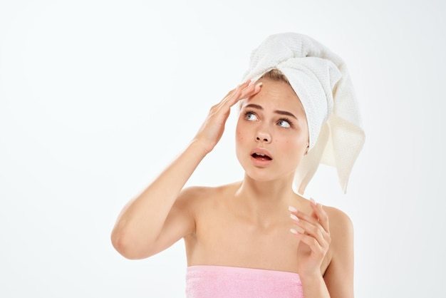 Woman with bare shoulders with a towel on her head clean skin