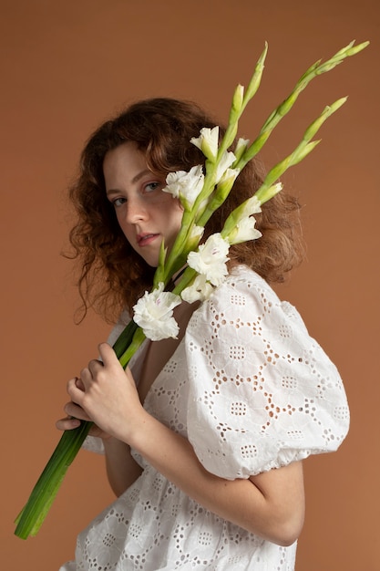 Photo woman with beautiful gladiolus flowers