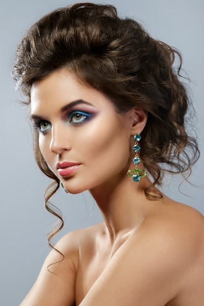 Woman with a beautiful makeup and hairstyle wearing shiny earrings