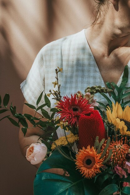 Donna con un bellissimo bouquet tropicale