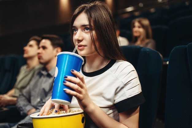 Donna con bevanda e popcorn seduto al cinema