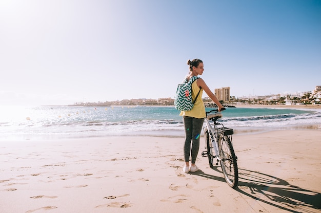 Woman with bicycle in the beach