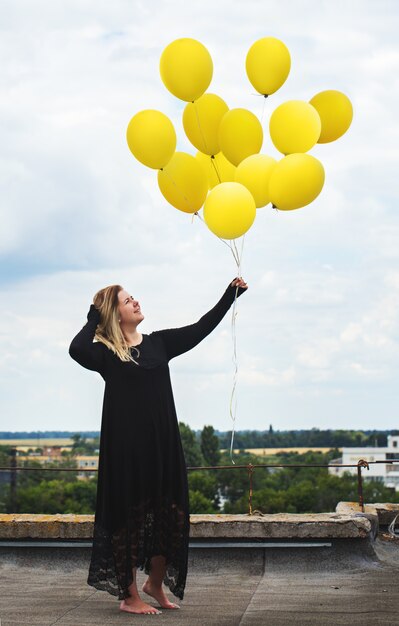 A woman with a big bunch of balloons