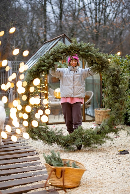 Woman with a big christmas wreath at backyard