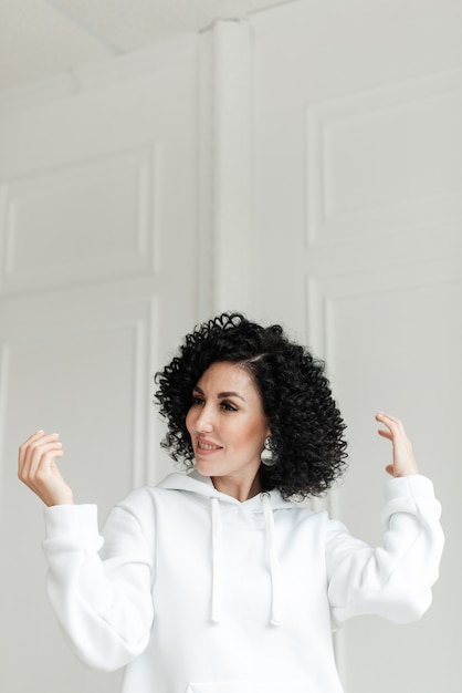 Woman with black curly hair posing