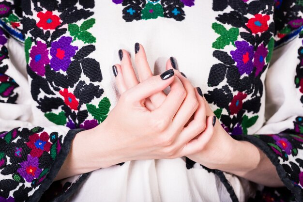 Woman  with black manicure in an old Ukrainian embroidered shirt