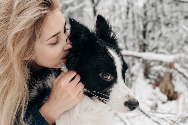 雪の中で黒と白のボーダーコリー犬と女性