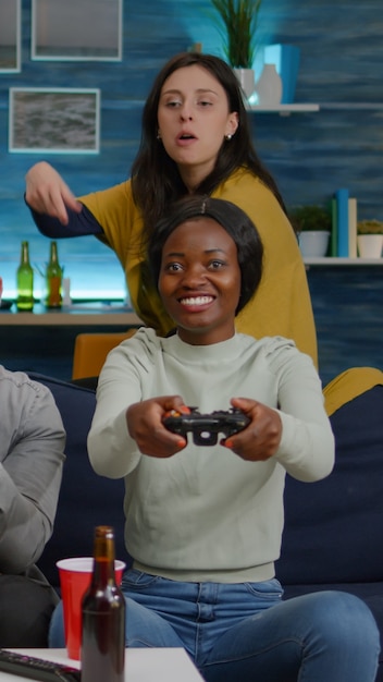 검은 피부를 가진 여성이 경쟁 시뮬레이션에서 남자 친구를 상대로 온라인 비디오 게임을 하고 있습니다.