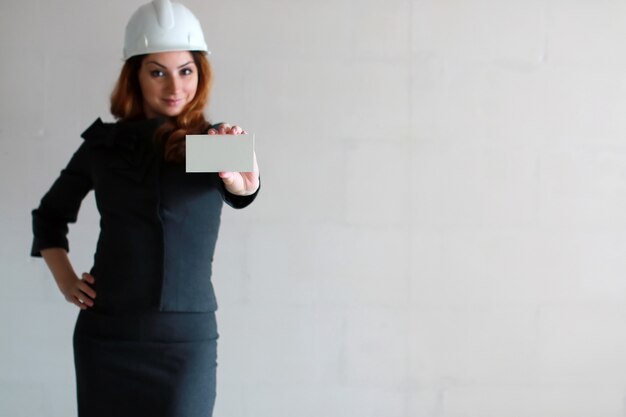 Woman with a blank sheet of paper in his hand on a construction site