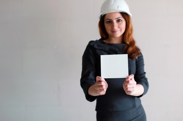 woman with a blank sheet of paper in his hand on a construction site