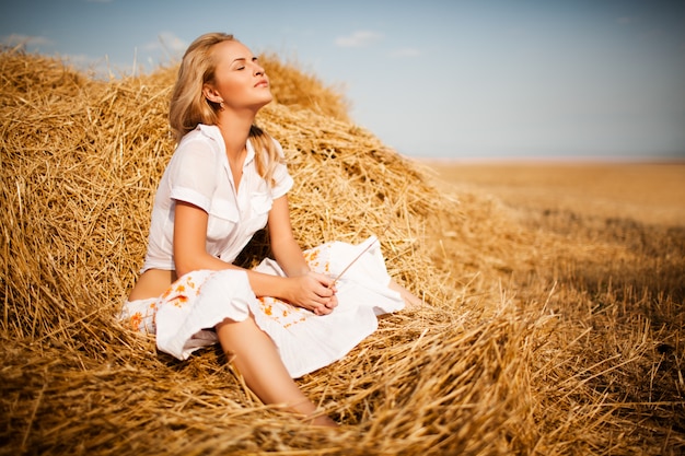 干し草で横になっているブロンドの髪を持つ女性