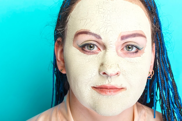 緑の粘土で作られた凍ったマスクで青いアフロブレードの顔を持つ女性