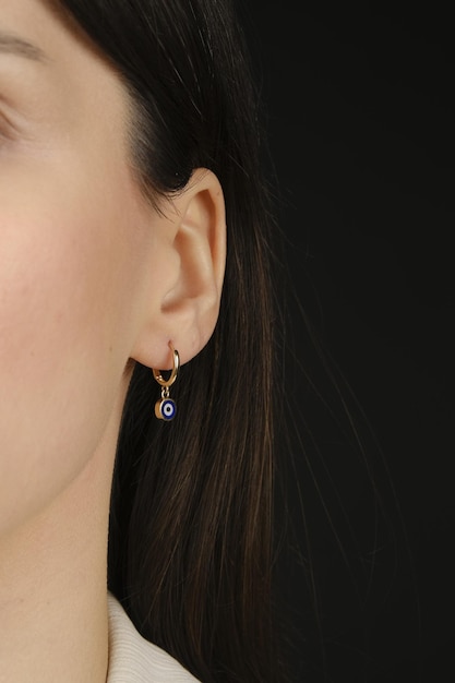 a woman with a blue beaded earring hanging from her ear