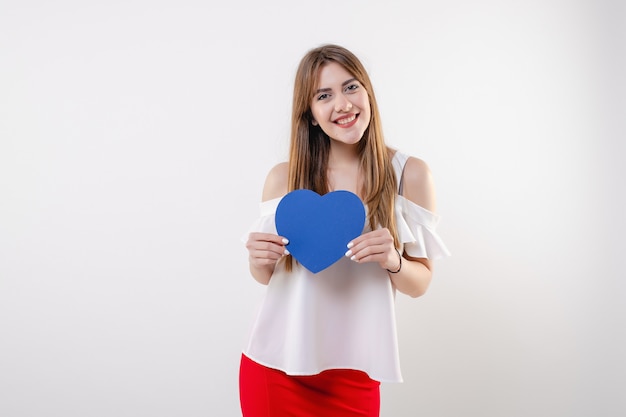 Woman with blue heart shaped valentine card smiling isolated