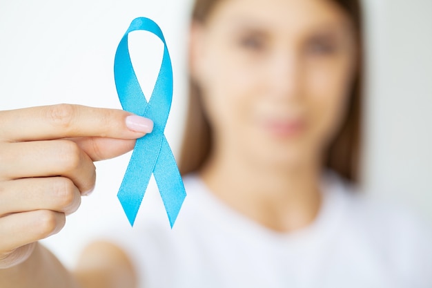 Woman with blue ribbon, prostate cancer awareness