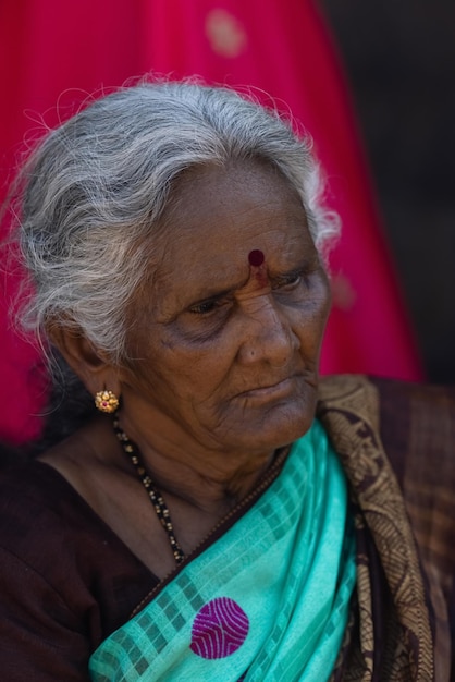 A woman with a blue saree looks into the distance.