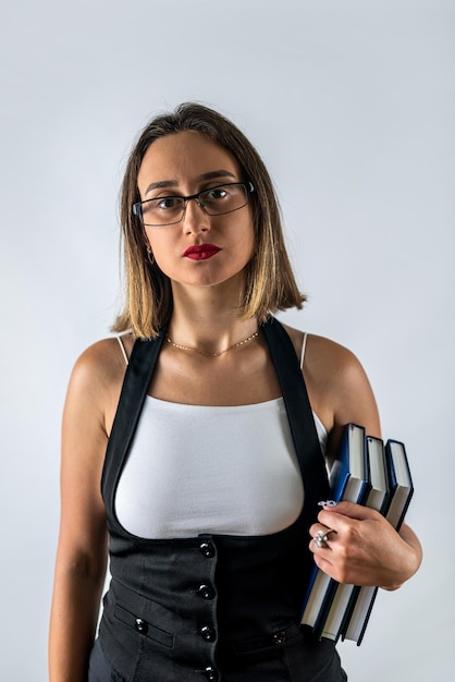 Woman with books in her hands posing in stylish clothes on an isolated white background