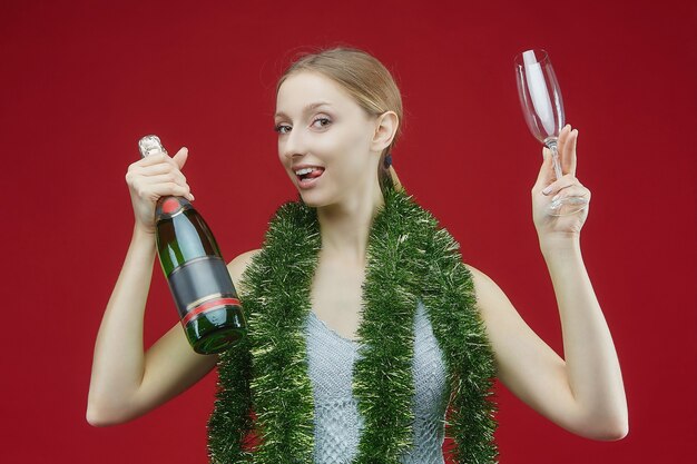 シャンパンのボトルと赤のガラスを持つ女性