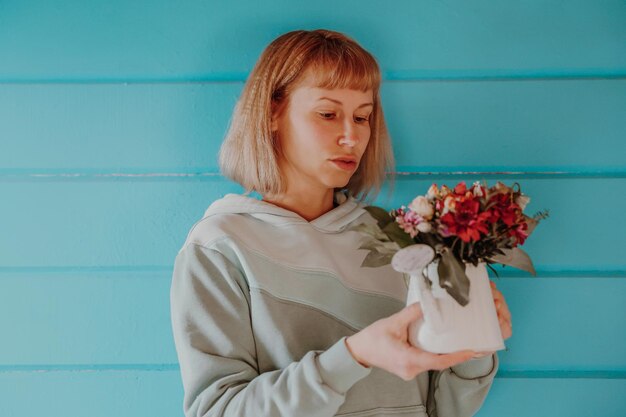 Woman with a bouquet of flowers on a blue background