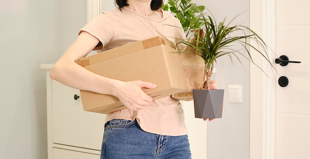 Woman with a box with things and a flower in her hands.