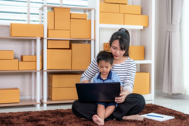 Woman with a boy working on a laptop on the floor