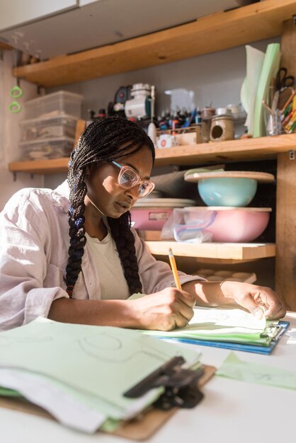 Woman with braided hair at her home office looking through the documents