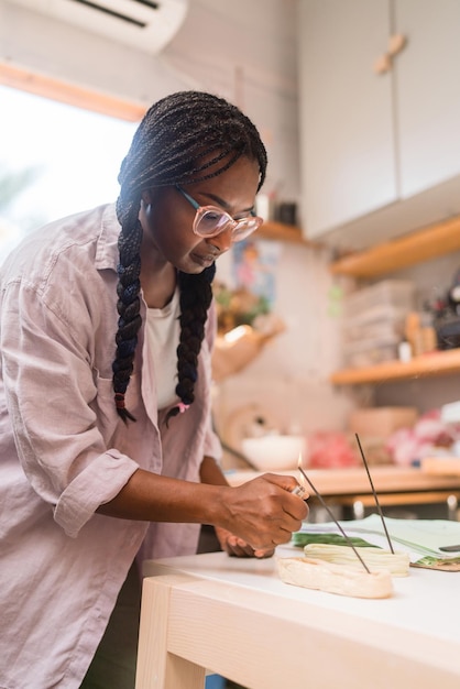 Photo woman with braided hair lighting up incense