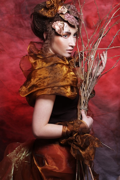 Woman with bright make up with dry branches