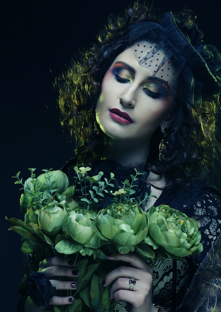 大きな緑の花を保持しているブリクト顔を持つ女性