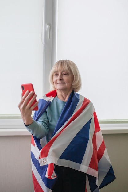 Woman with british flag makes selfie to celebrate platinum\
jubilee of queen in social media