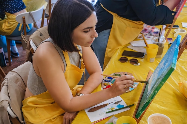 Woman with brush painting on canvas