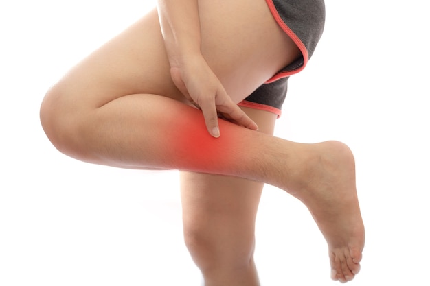 Woman with calf feeling pain on white background women suffering from pain in the leg
