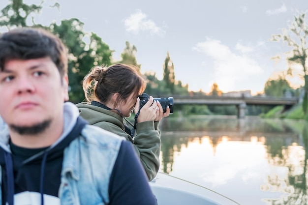 カメラを持った女性がボートから自然の写真を撮り、川に沿って航海します