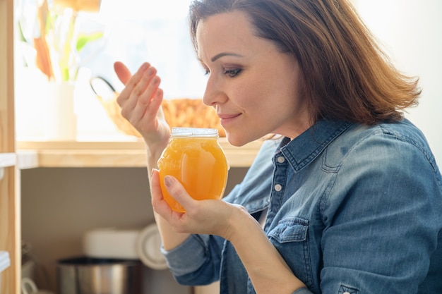 Foto donna con la latta di miele dorato organico naturale fresco