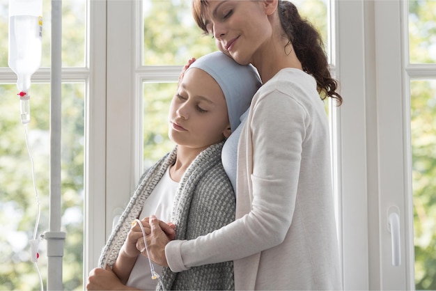 A woman with a cancer patient is hugging her head.