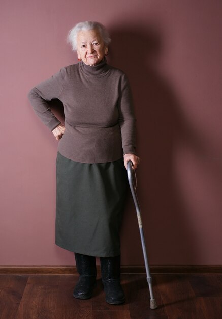 woman with a cane isolated on brown