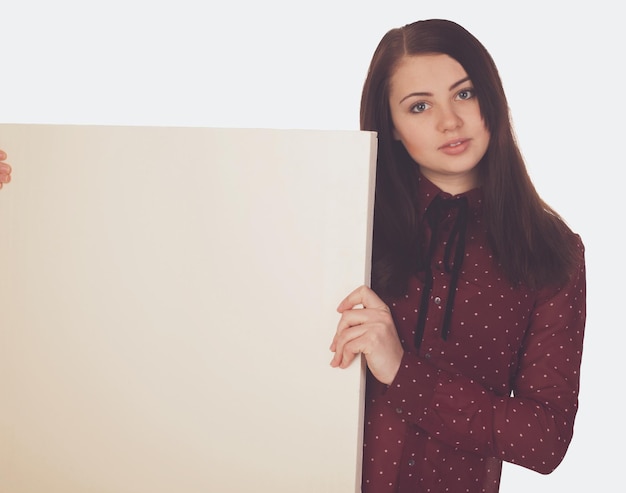 Woman with canvas is standing against  of white background