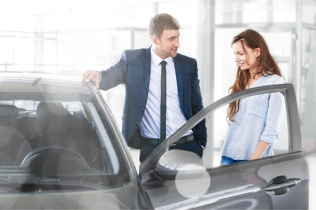 Woman with car dealer in auto show or salon