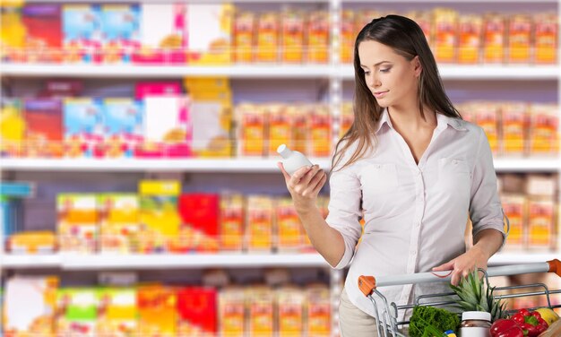 Woman with cart shopping in supermarket