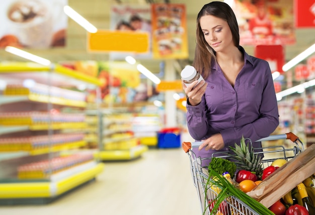 Woman with cart shopping in supermarket