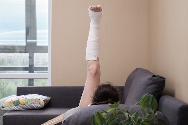 足にギプスをつけた女性が運動をしている。怪我後のリハビリテーション。