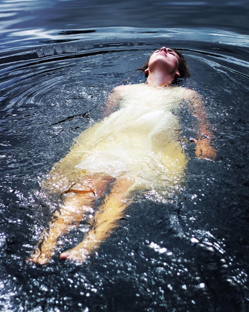 Foto donna con abiti casuali che galleggia sull'acqua