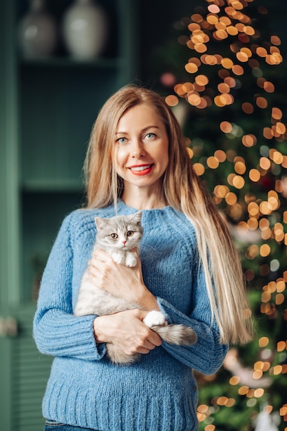 A woman with a cat hugs at home