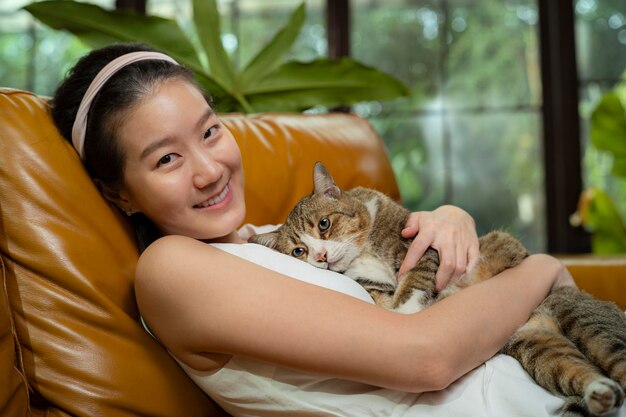 Woman with cat relaxing on sofa at home